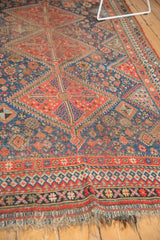 Intricate border and geometric patterns on a vintage Qashqai rug, showing wear.