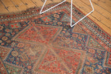 Vintage Qashqai geometric boteh and pinwheel patterns in brick red, navy blue, with harder wear.