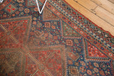 Vintage Qashqai carpet, brick red and navy geometric patterns, with visible wear to foundation.