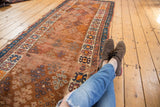 Antique Caucasian runner featuring an allover guli hennai motif in bronze, blue, and orange.
