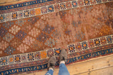 Antique Caucasian runner's guli hennai pattern with aged copper tones and geometric blue borders.