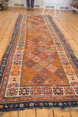 Antique Caucasian runner's dark blue floral border, ivory geometric, and copper guli hennai motifs.