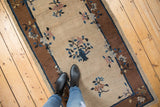 Peking rug's natural gray beige field featuring ornate vase and delicate floral sprays.