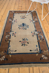 Frayed end and bronze border of the Peking rug, featuring natural beige and floral motifs.