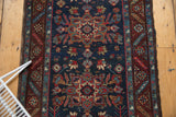 Hand-knotted vintage Persian Heriz rug with navy blue field, geometric florals, wine red border.