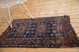 Vintage Heriz rug with geometric double medallion, navy, wine red, sky blue, and mostly even wear.