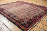 Vintage Lilihan rug corner, intricate dusty raspberry field, worn pile, secured navy border.