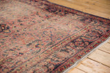 Faded cherry red and navy blue intricate border of vintage Lilihan rug with visible wear and fringe.