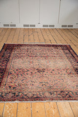 Fringed end of Lilihan rug, faded cherry red and navy border, with even wear.