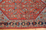 Antique Bijar rug's vibrant brick red field, herati motif, and distinct serrated sky blue border.