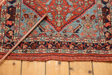 Intact macrame finish and detailed red and blue border of an antique Bijar rug.