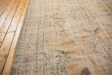 Distressed Oushak carpet with worn pile texture, showing pale apricot, sandlewood, and faint blue details.