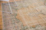 Textured distressed Oushak rug with faded apricot field, mint green, and ivory floral patterns.