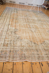 Distressed vintage Oushak rug showing worn apricot field, mint green border, and secured fringe.