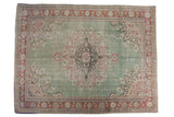 Distressed vintage Oushak rug with pale mint green field and bursting medallion.