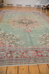 Detail of distressed texture, showcasing brilliant blush, raspberry, and celadon green border patterns.