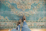 Distressed sky blue Oushak rug texture with ivory scrolling arabesques and visible wear.