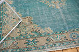 Vintage Oushak corner detail: sky blue field, distressed beige spandrels, visible foundation.