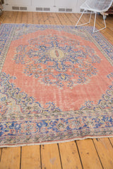 Distressed dusty blush field, royal blue scrolling border, and fringe of vintage Oushak rug.