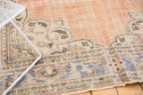 Distressed Oushak carpet corner with faded rose abrashed field and European-style spandrel.