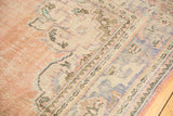 Distressed Oushak rug pile with visible knot wear, pale rose, antique ivory, and faded blue.