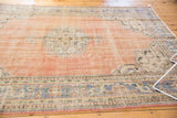 Distressed Oushak rug featuring an abrashed field and faded rose and blue tones.