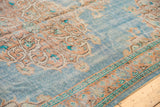 Distressed sky blue Oushak corner spandrel with apricot scrolling vinery and patterned border.