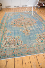 Distressed vintage Oushak rug lower border and fringe, showing even wear with sky blue, apricot, and beige.