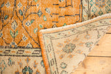 Distressed vintage Oushak rug with apricot scrolling vinery, secured side, and woven reverse.