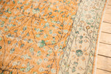 Distressed Oushak rug's apricot field with mint vinery and ivory border showing mostly even wear.