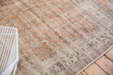 Distressed Oushak carpet border, with scrolling vinery in pale apricot and ivory hues.