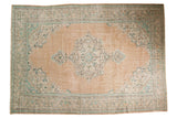 Vintage distressed Oushak carpet with a Rococo-style scalloped medallion on a pale peach field, mint green, apricot tones. 7'2