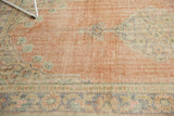 Close-up of distressed Oushak rug showing even wear, faint foundation, and muted patterns.