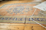 Distressed Oushak rug border with faded royal blue and apricot blossoming floral motifs.