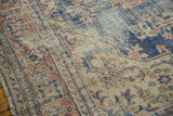 Distressed vintage Oushak rug close-up, with time-softened navy, terracotta, and ivory pile.