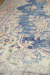 Textured distressed Oushak pile with worn knot heads, navy blue, and pale terracotta florals.