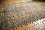 Distressed Oushak carpet corner, with apricot field, navy motifs, and shorn pile.