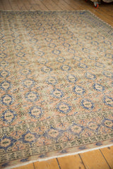 Low shorn pile and decorative border of a distressed Oushak carpet with pale navy and apricot.