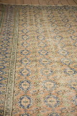 Distressed Oushak rug's low pile, revealing apricot, navy mini medallions, and foundation.