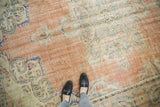 Distressed pile of vintage Oushak rug, pale blush, ivory, seafoam green floral motifs.