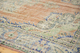 Distressed Oushak carpet border featuring elongated botehs, floral palmettes, and faded blush field.
