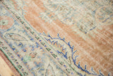 Distressed Oushak rug texture with mostly even wear to knot heads, apricot and blue tones.