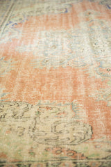Vintage distressed Oushak carpet texture with mostly even wear, faded blush and ivory.
