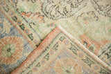 Distressed vintage Oushak pile texture and secured side in soft blush, seafoam, ivory.