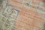 Distressed texture of Vintage Oushak rug, pale apricot field, ivory floral motifs, mostly even wear.