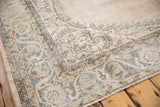 Distressed vintage Sparta rug corner with ivory, pale sand gold, and ocean green-blue border.