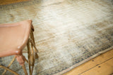 Distressed Oushak rug with extensive wear, exposed foundation, and subtle sand tones.