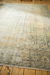 Distressed vintage Oushak rug corner, showing foundation wear, faded blue patterns, and fringe.