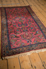 Corner of vintage Persian Lilihan rug, with raspberry field and intricate navy border.
