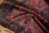 Close-up Lilihan rug pile; dark raspberry red field, navy blue floral vinery, and fringe.